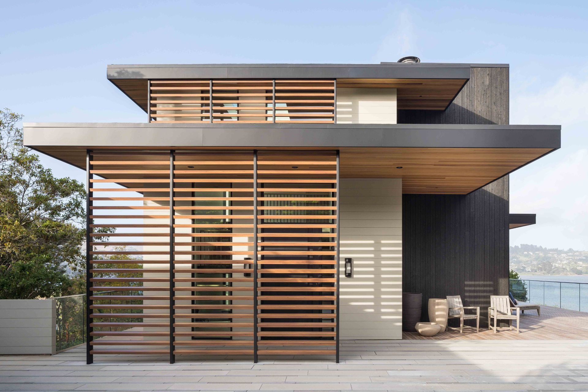 House with light and dark wooden facade and screen elements